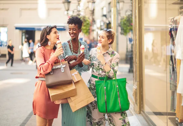 Three women shopping with bags eating ice cream on city street, lifestyle influencer content