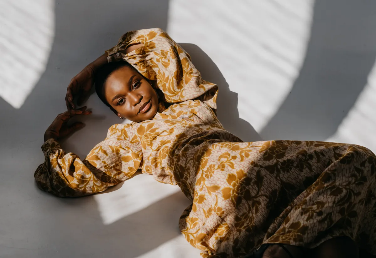 Fashion influencer in golden patterned outfit posing for lifestyle brand campaign photography