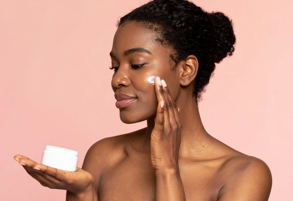 Woman applying face cream from white jar in skincare beauty product demonstration